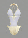 Back studio view of ivory halter cutout one-piece swimsuit with open back and tie details for beach party styling