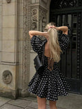 Black open-back polka dot dress with corset ties