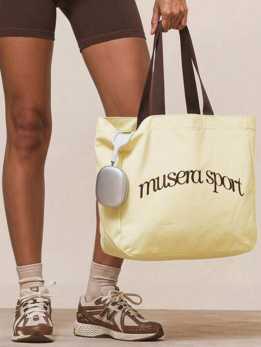 Pale yellow canvas sport tote bag with brown logo and shoulder straps
