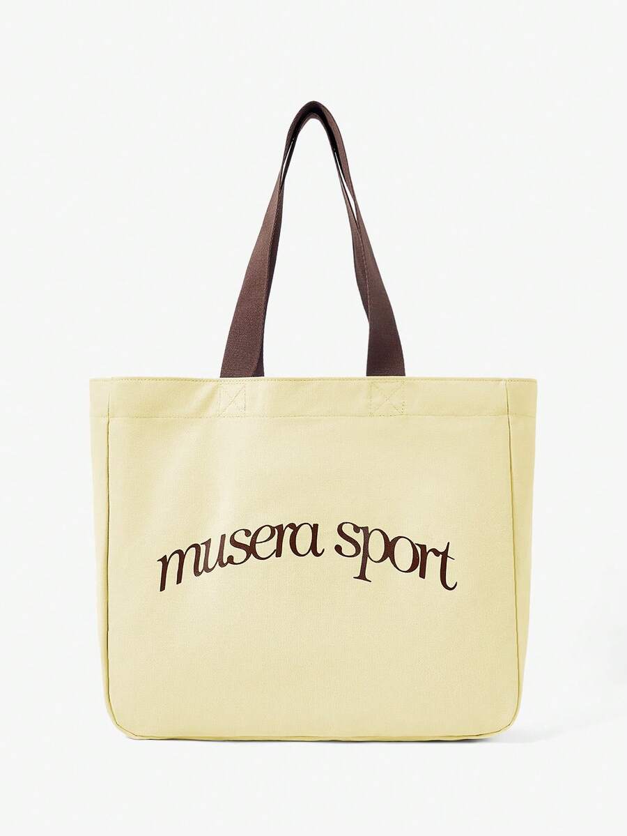 Close view of pale yellow logo tote showing reinforced strap stitching