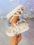 White flatform slingback sandals handheld detail showing crisscross strap layout
