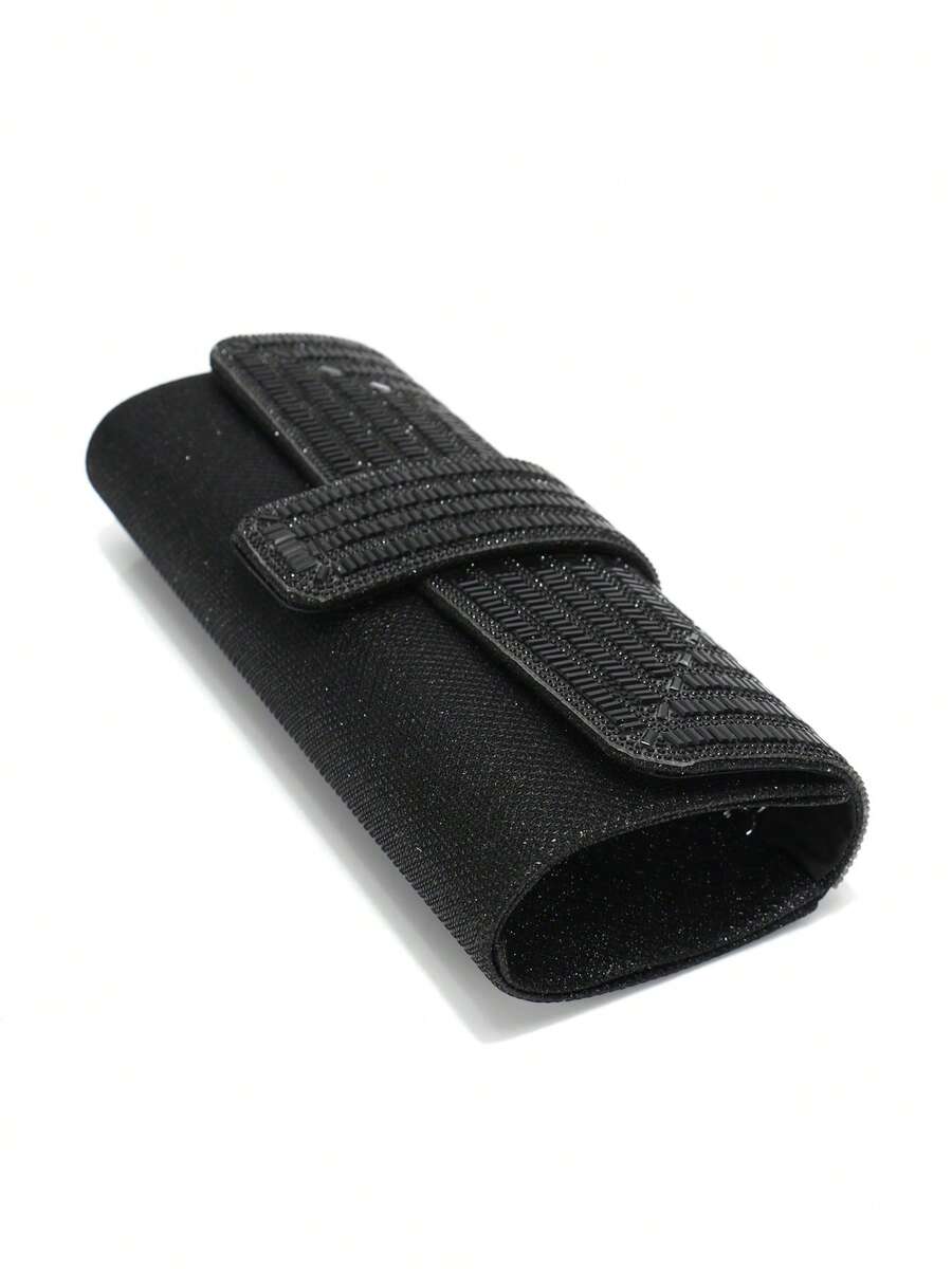 Side angle black glitter envelope clutch showing rounded gusset flap and center tab