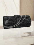 Black rhinestone evening clutch with silver chain strap draped across front
