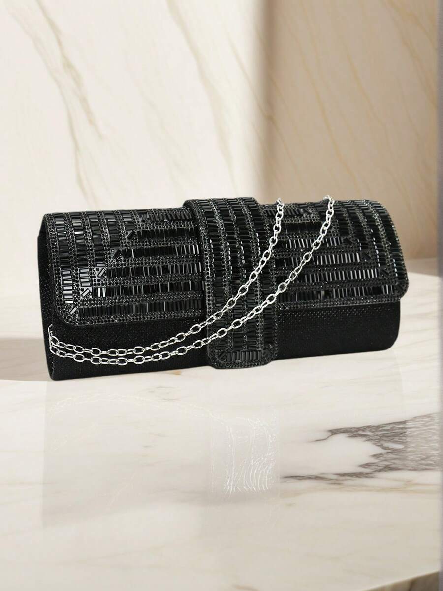 Black rhinestone evening clutch with silver chain strap draped across front
