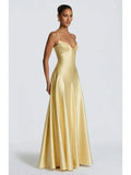Three-quarter view of the yellow-gold long evening dress showing its smooth fitted bodice