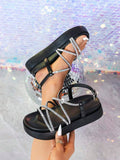 Black rhinestone platform sandals handheld view with crystal crisscross strap detail