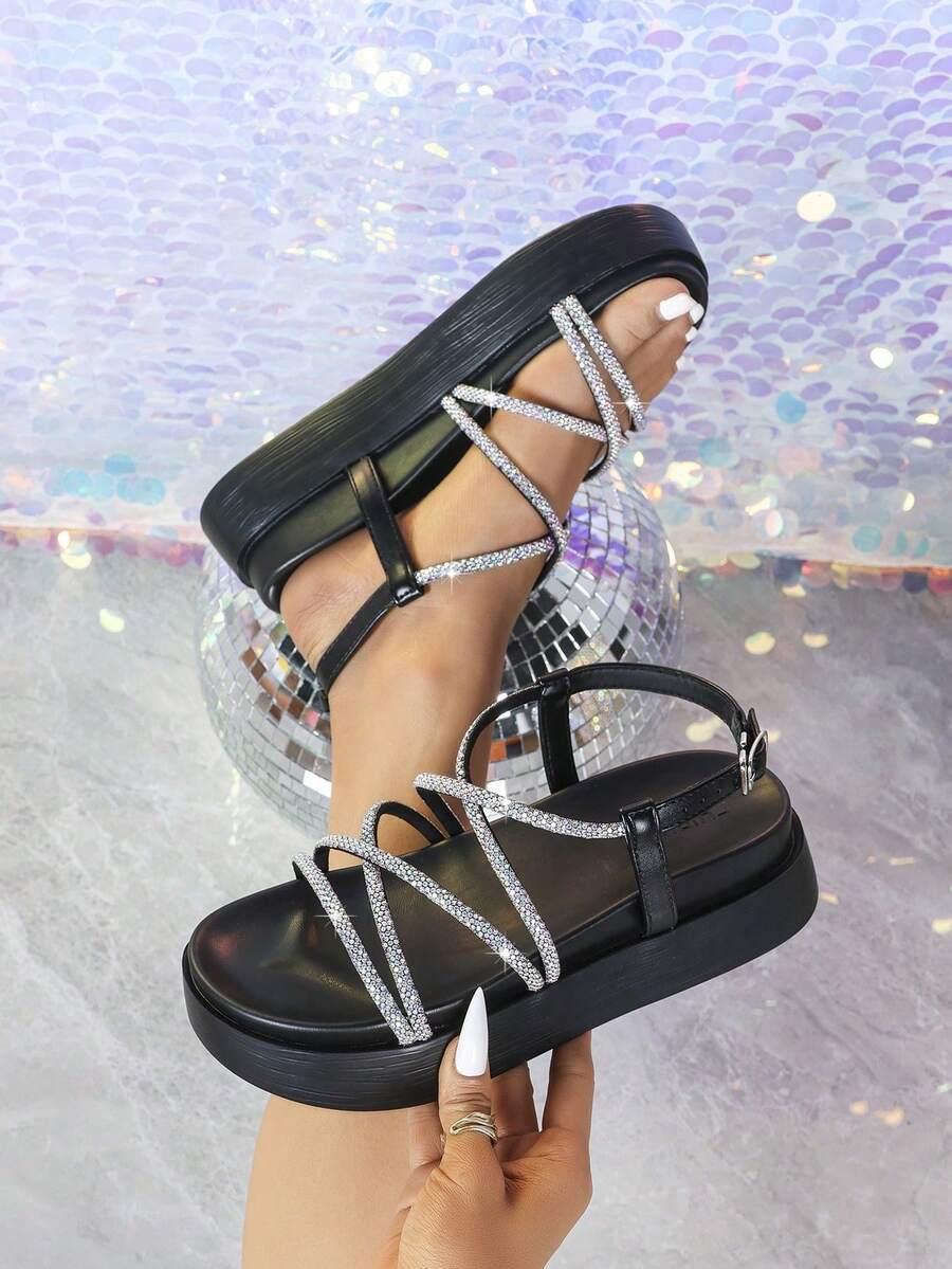 Black rhinestone platform sandals handheld view with crystal crisscross strap detail