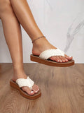 Side on-foot view of brown platform flip-flops with ivory bobble-edged straps