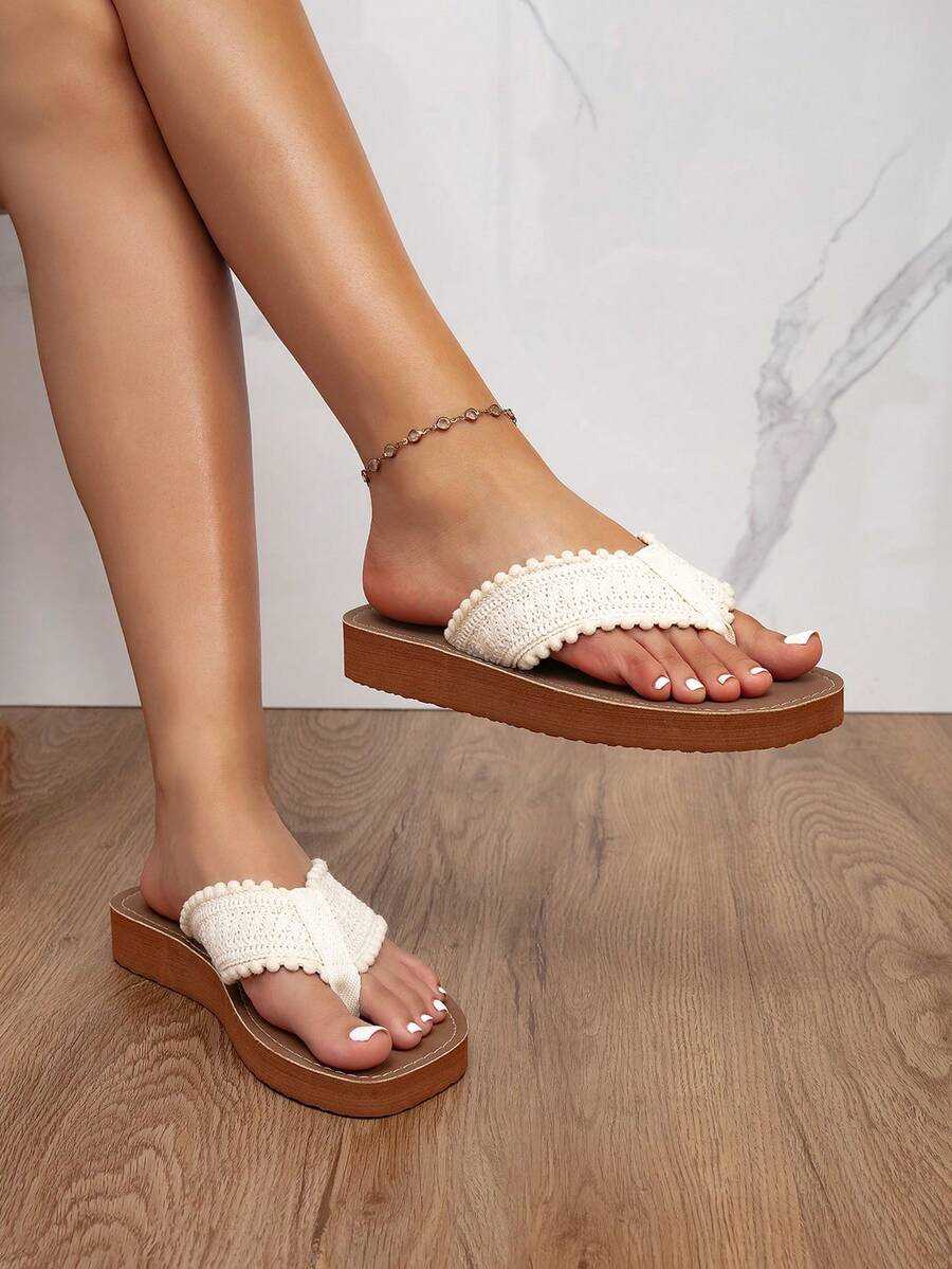 Side on-foot view of brown platform flip-flops with ivory bobble-edged straps