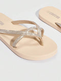 Close-up studio view of beige jeweled thong flip flops as a pair