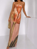 Three-quarter view of blush floral-print strapless maxi dress with oversized flower graphic for vacation wear