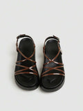 Brown glossy platform sandals top view showing crossed forefoot straps and black sole
