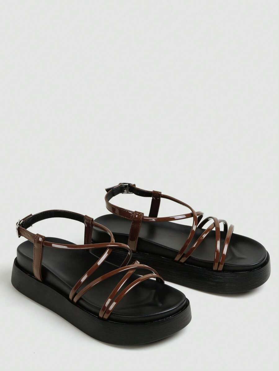 Brown glossy crisscross flatform sandals studio view with black footbed and buckle strap
