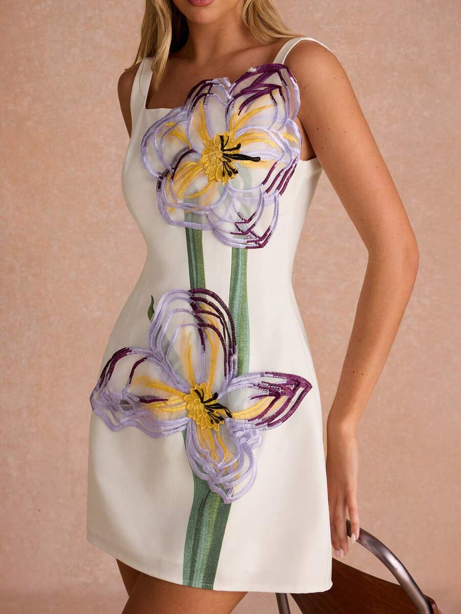 Close front view of white sleeveless mini dress with lavender and yellow floral appliqués