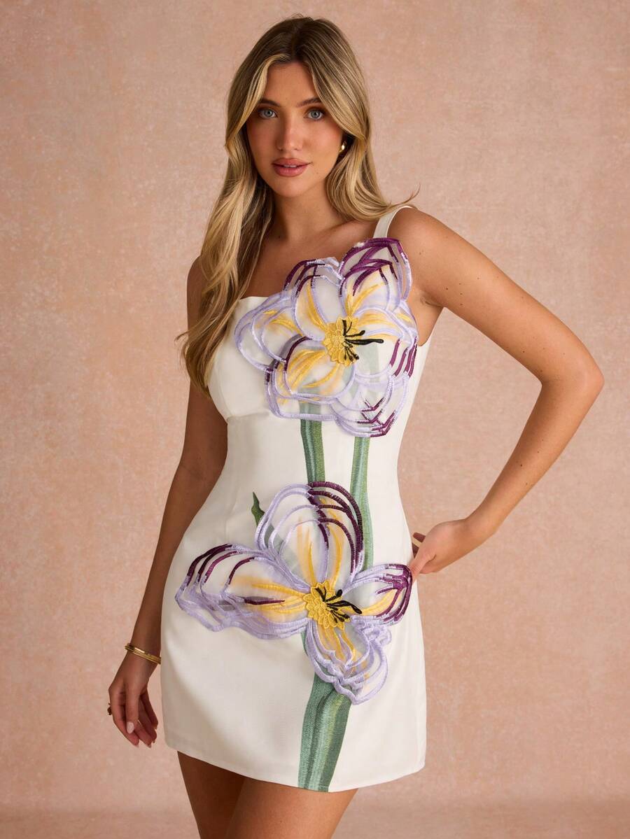 Three-quarter view of white sleeveless floral appliqué occasion dress with straight hem