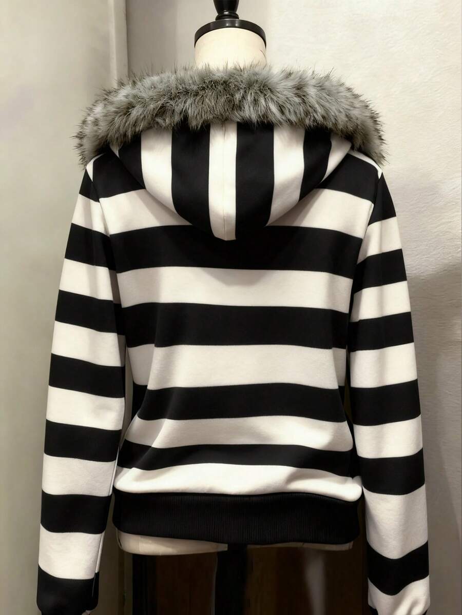Back view of black and white striped hooded zip-up jacket with faux-fur trimmed hood