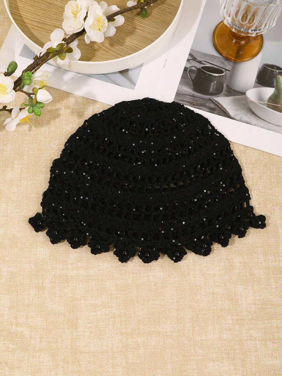 Close view of black hollow out crochet hat with shiny floral finish