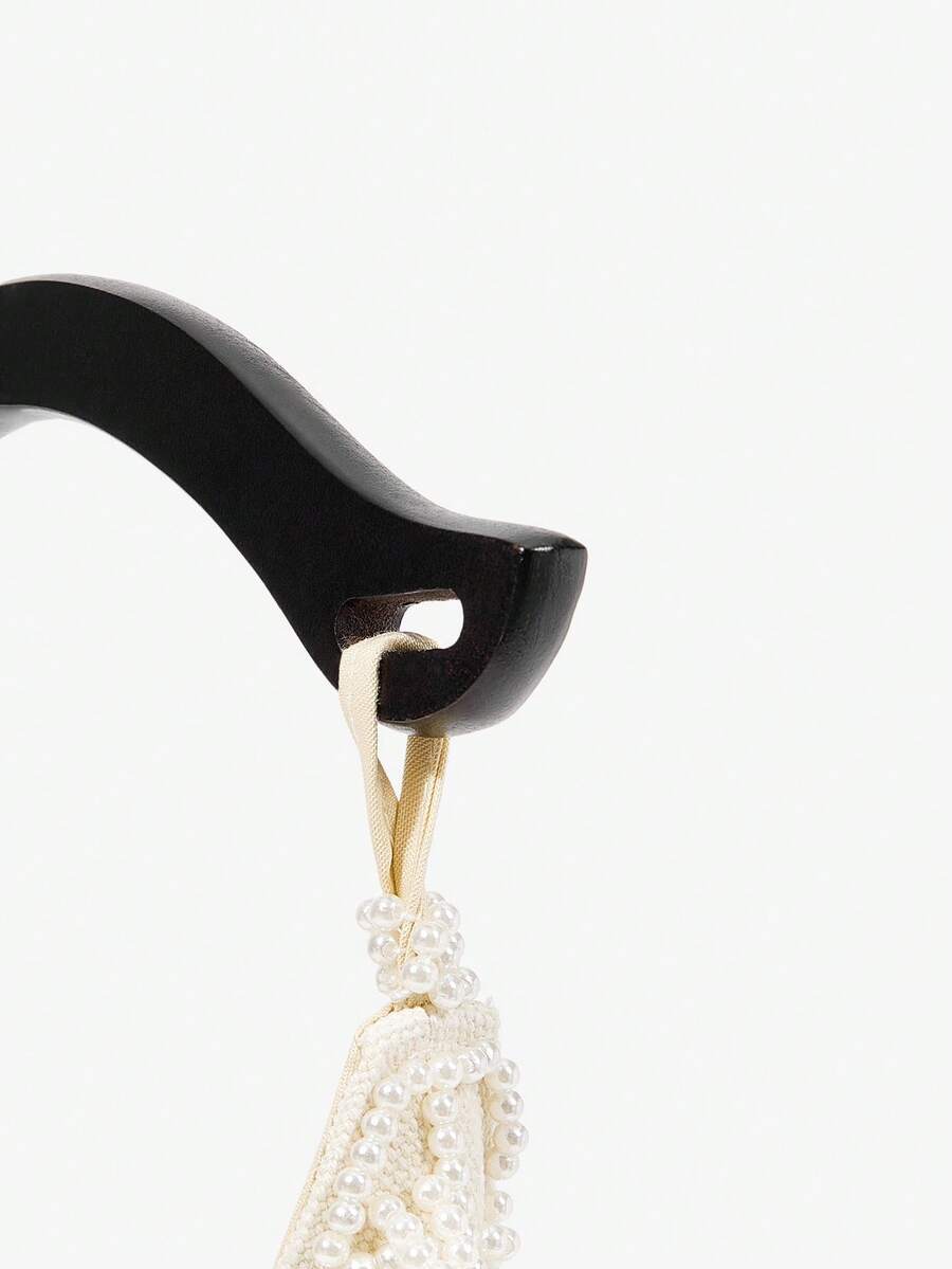 Close view of shell beaded mini bag with cowrie fringe and pearl net texture