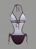 Back studio view of dark burgundy halter cutout one-piece swimsuit with open back and tie details for beach party styling