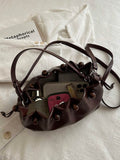 Brown drawstring shoulder bag showing side knots and flat base