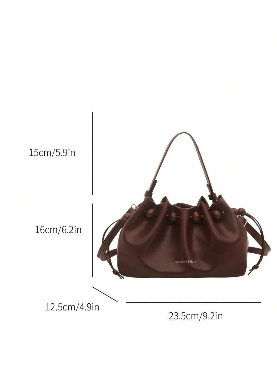 Brown glossy faux leather bucket bag showing pleated top and adjustable strap