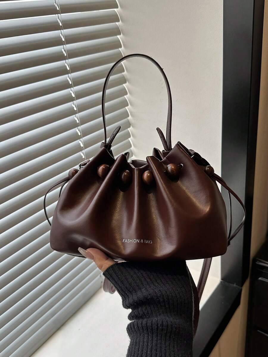 Dark brown small drawstring bucket shoulder bag with wood bead trim and top handle