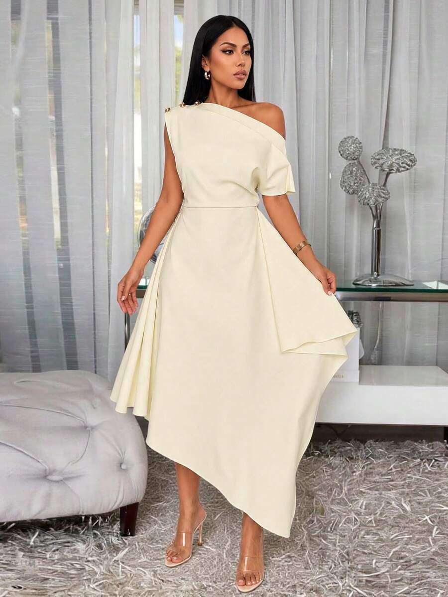 Front angled view of cream one-shoulder midi dress with gold-tone buttons and pointed high-low hem