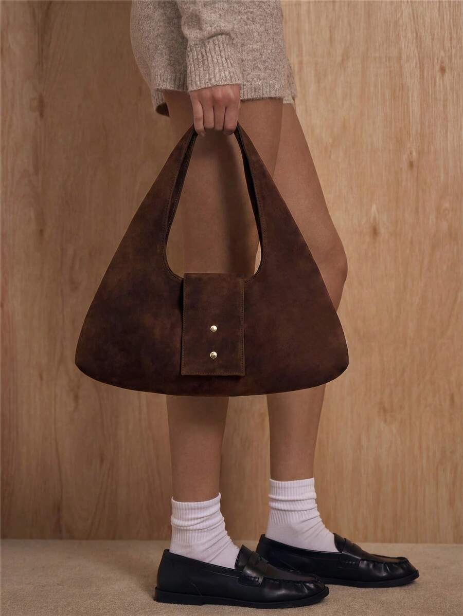 Dark brown crescent shoulder handbag with padded body and center flap tab