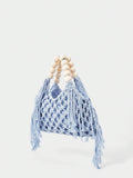 Light blue crochet beach bag angled view with net knit body fringe sides and bead handle