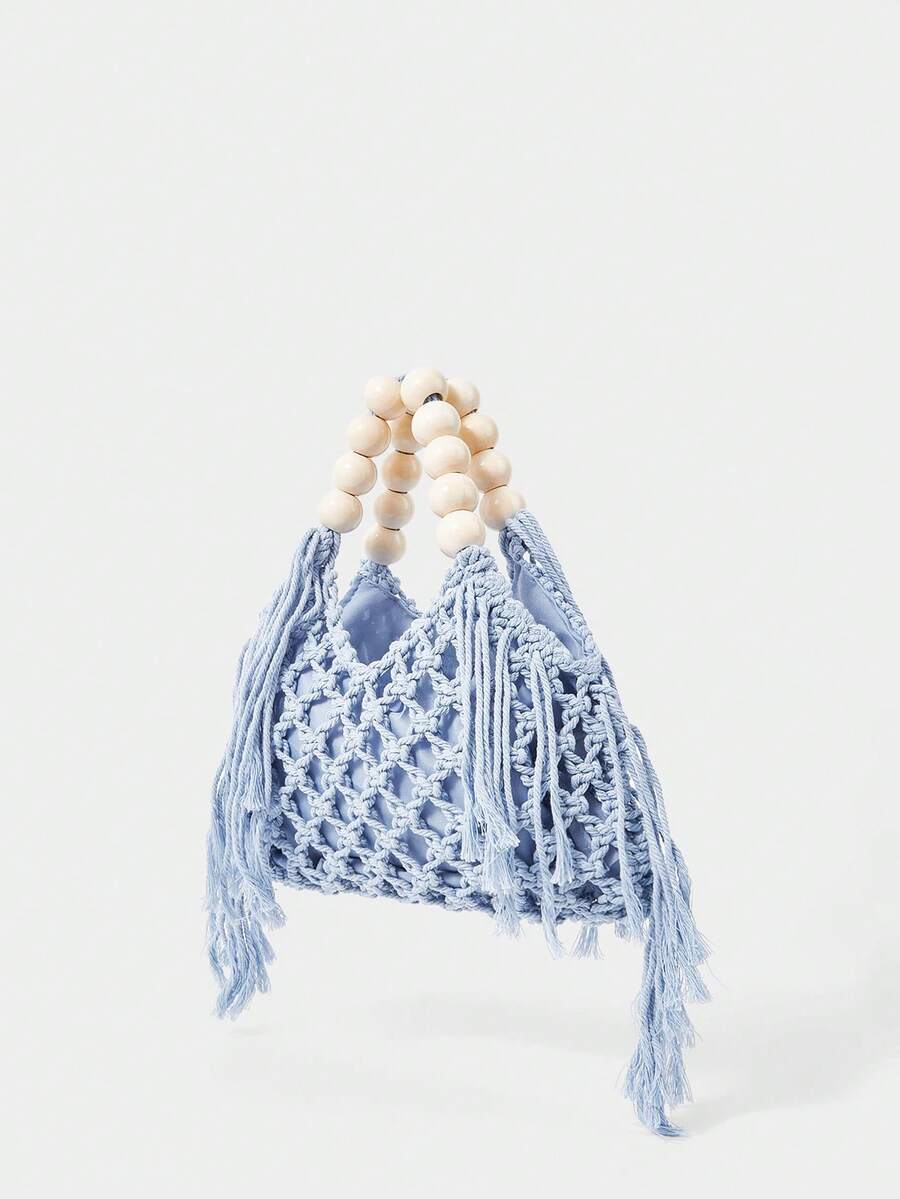 Light blue crochet beach bag angled view with net knit body fringe sides and bead handle