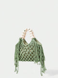 Green crochet beach bag angled view with open knit body fringe sides and bead handle