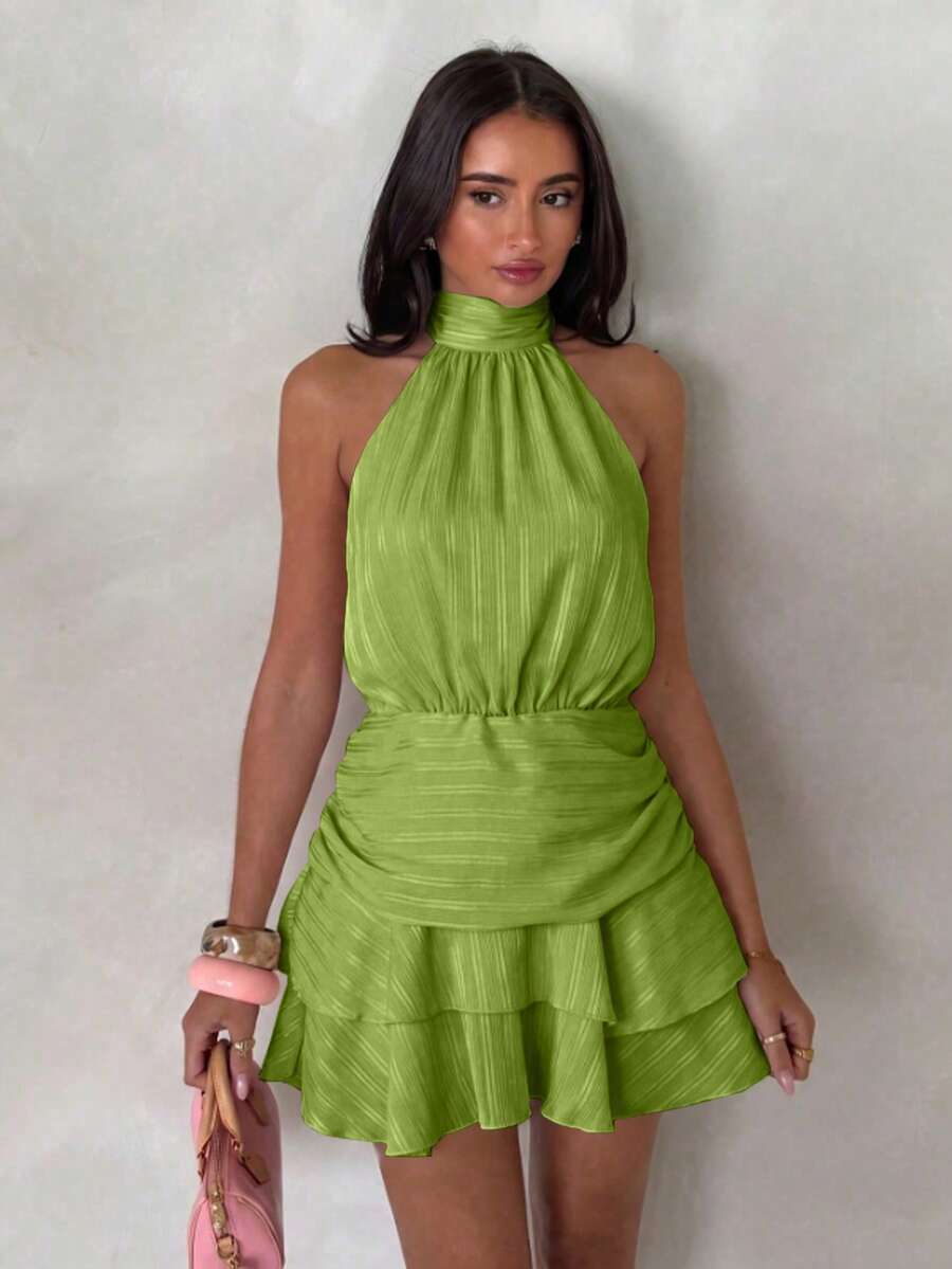 Front view of green halter mini dress with gathered waist and tiered hem