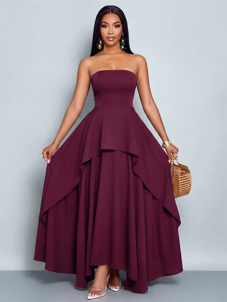Full front studio view of burgundy strapless maxi dress with layered asymmetric waterfall skirt