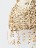 Close view of beige shell fringe crochet bag with open net texture and wrapped handles