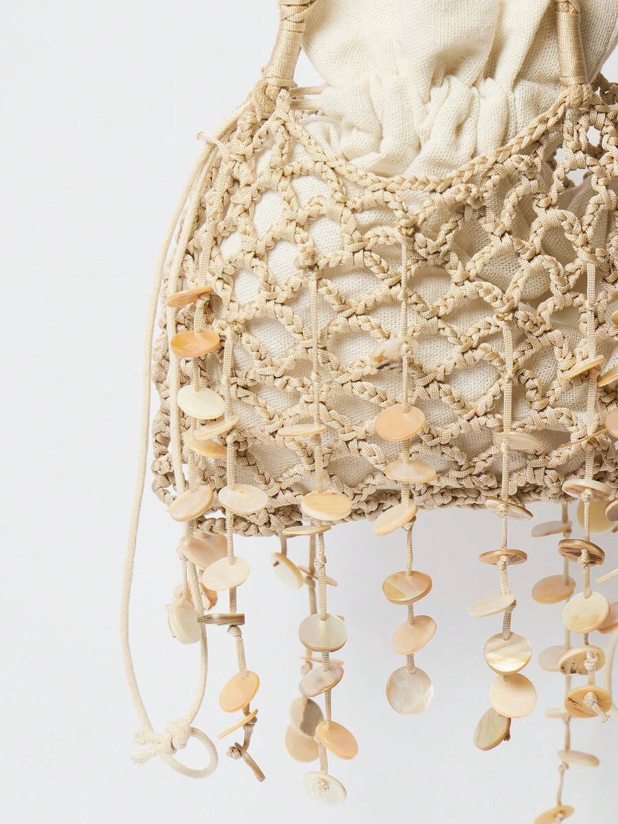 Close view of beige shell fringe crochet bag with open net texture and wrapped handles