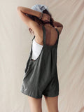 Rear three-quarter view of black pinstriped playsuit showing low back and loose shorts