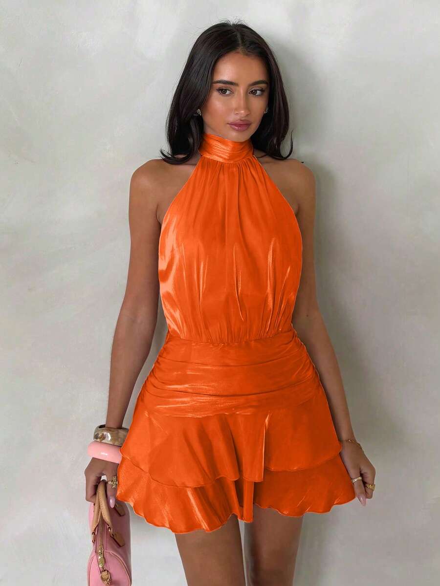 Front view of orange halter mini dress with gathered waist and tiered ruffle hem