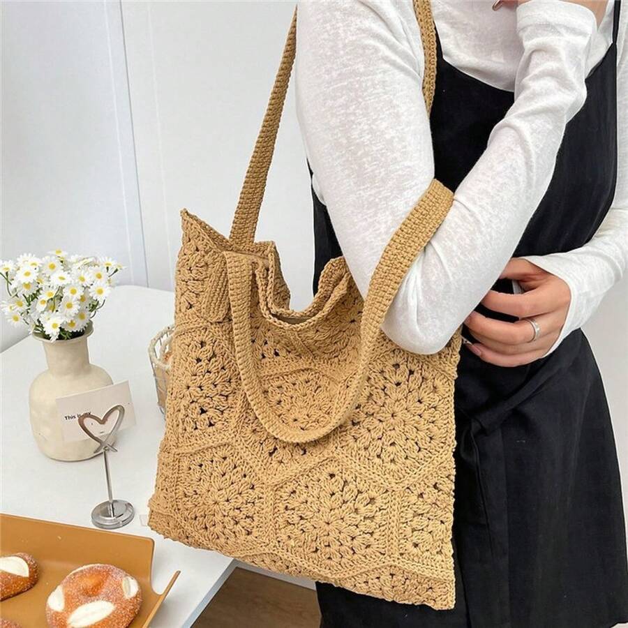 Lifestyle shoulder view of tan crochet woven tote bag with slouchy open top