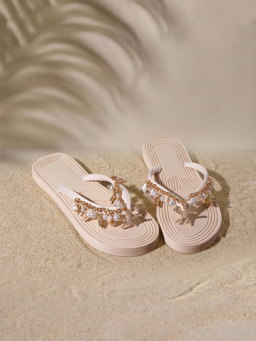 Top angled view of beige platform thong sandals with pearl chains, rhinestones and layered soles for beach styling