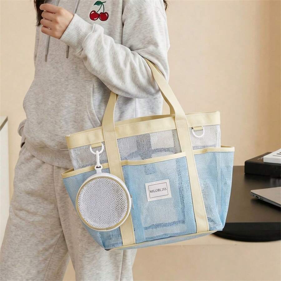 Worn front view of light blue open top mesh tote bag with exterior pockets
