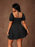 Rear view of black and white polka-dot mini dress with tie straps, smocked back and puff sleeves