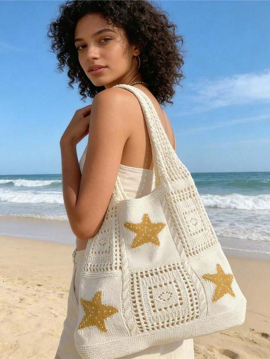 Shoulder worn beach view of cream crochet tote bag with yellow stars and open mesh