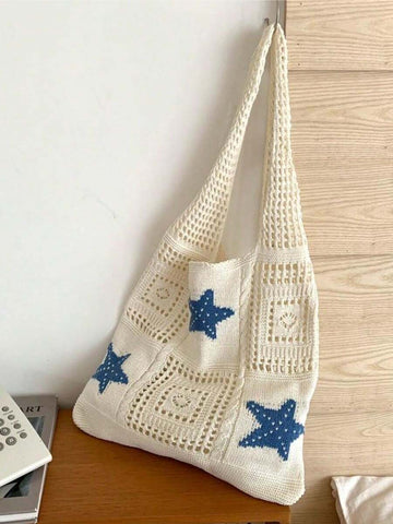 Indoor hanging view of cream crochet beach tote bag with blue star patches