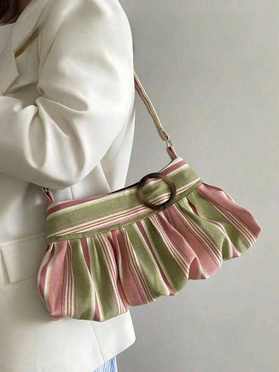 Worn side view of pastel striped pleated shoulder bag with ring accent and adjustable strap