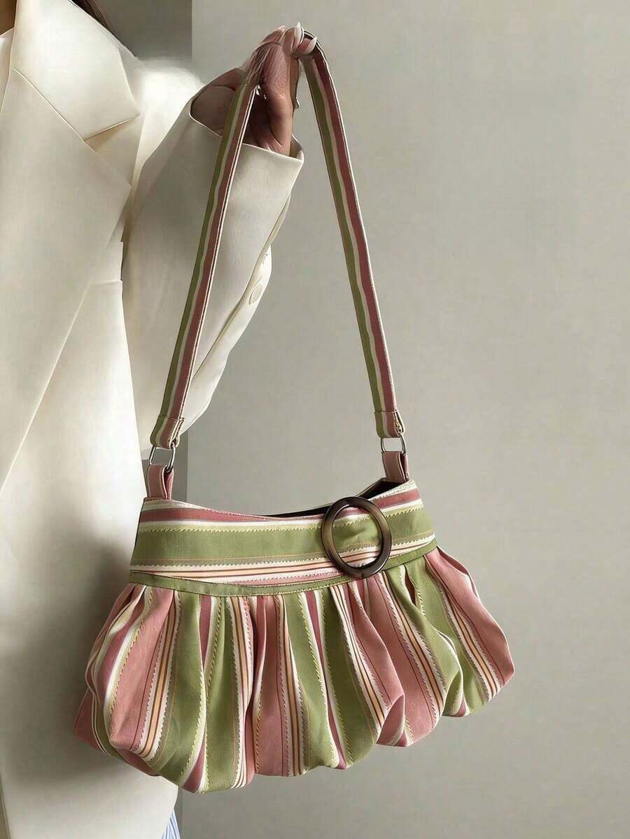 Worn side view of pastel striped pleated shoulder bag with ring accent and adjustable strap