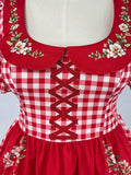 Close-up of gingham floral dress collar and decorative crisscross bodice detail