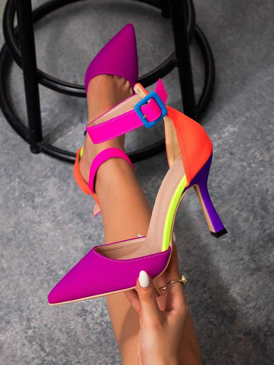 Hand holding fuchsia multicolor pointed ankle strap stiletto pump