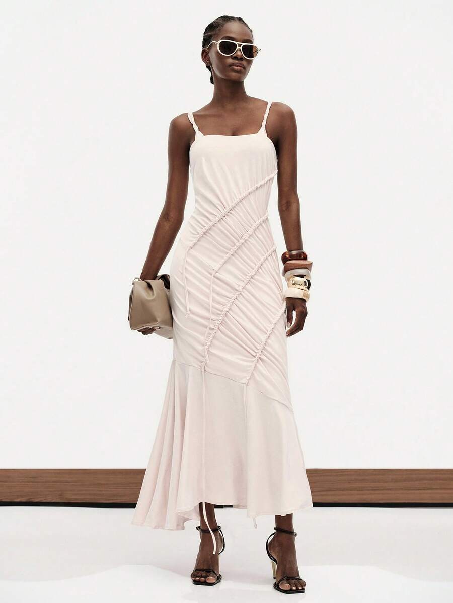 Front view of apricot pleated spaghetti strap dress with square neckline, fitted bodice, and flared hem