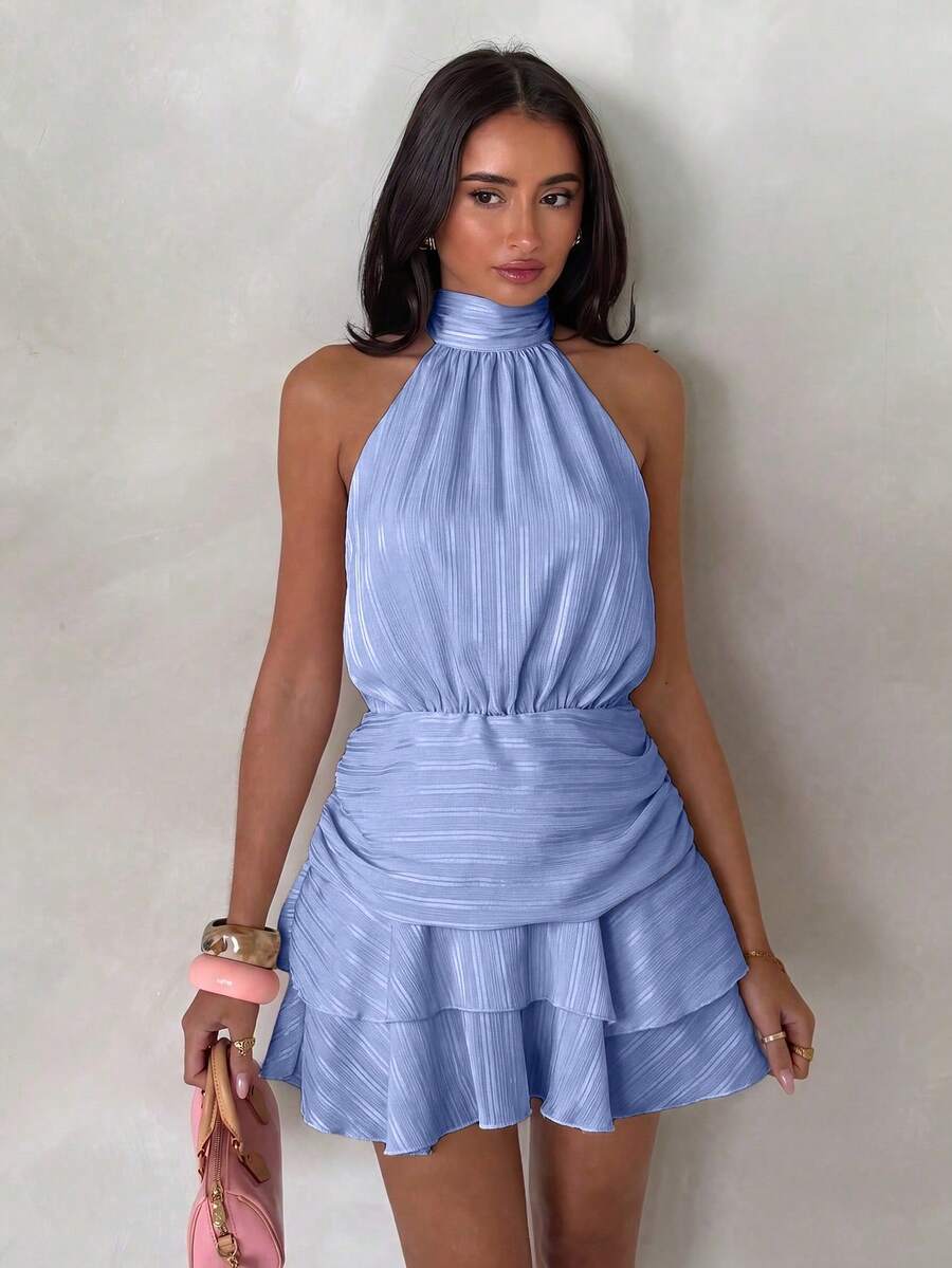 Front view of blue halter mini dress with gathered waist and layered hem