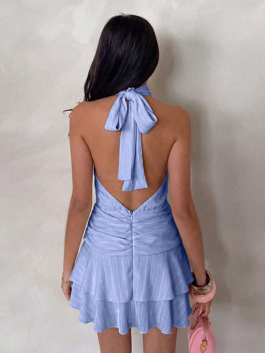 Back view of blue halter mini dress with tied neck and open V back